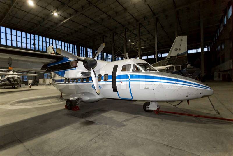 Luxury private airplane in hangar on maintenance, stock photo