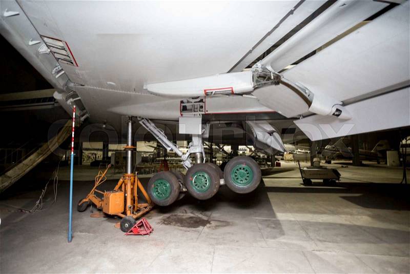 Maintenance of passenger aircraft chassis at hangar before flight, stock photo