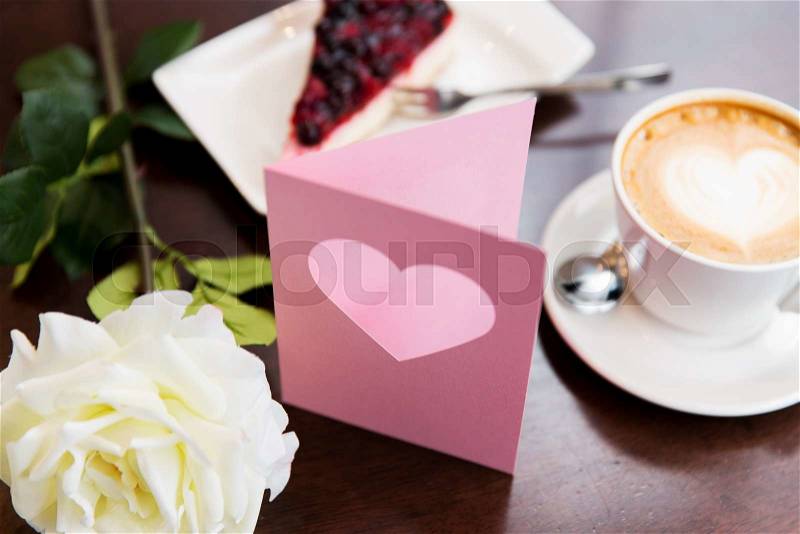 Holidays, valentines day and love concept - close up of greeting card with heart, flower, cake and coffee, stock photo