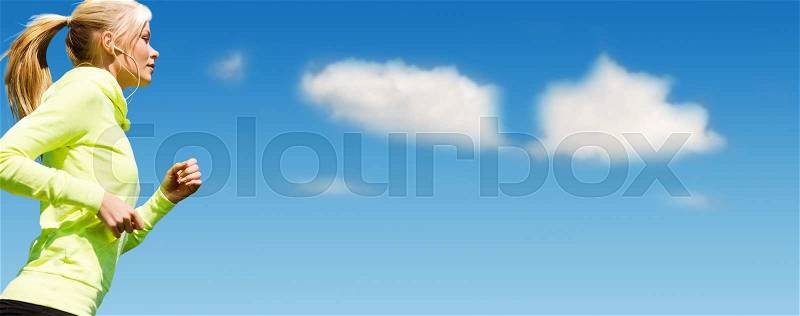 Sport, fitness, exercising, people and lifestyle concept - sporty woman with earphones listening to music and running over blue sky and clouds background, stock photo
