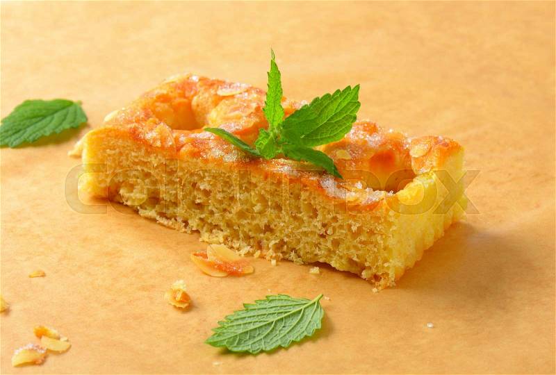 Slice of sponge cake topped with almond flakes, stock photo