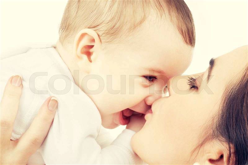 Family and happy people concept - mother kissing her baby, stock photo