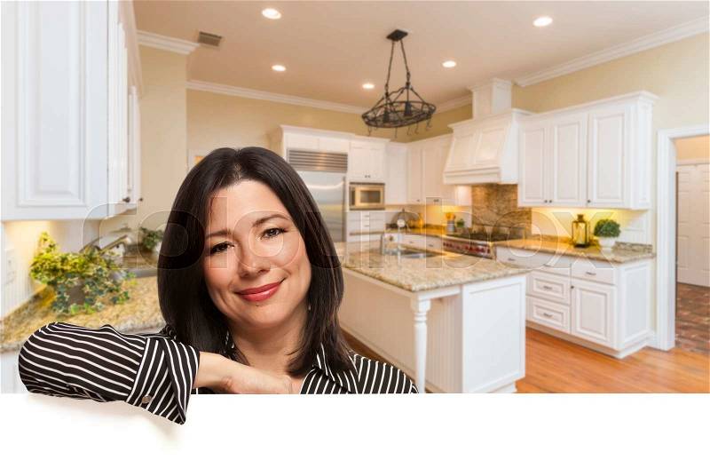 Hispanic Woman Leaning Against White Board In Custom Kitchen Interior, stock photo