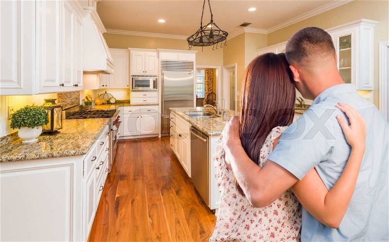 Young Hopeful Military Couple Looking At Beautiful Custom Kitchen, stock photo