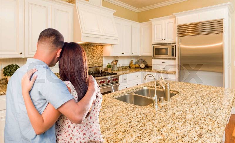 Young Hopeful Military Couple Looking At Beautiful Custom Kitchen, stock photo