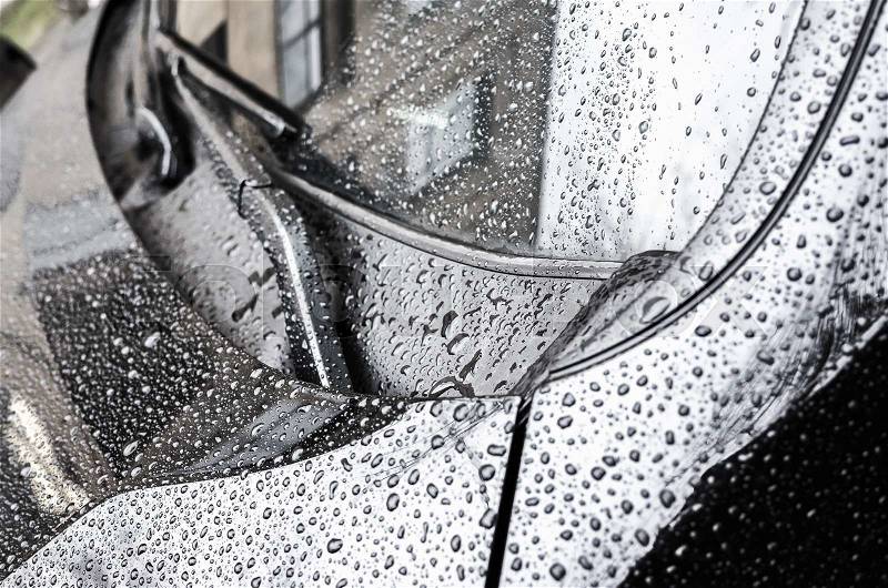 Black metallic shining car hood fragment and windshield wipers with raindrops on it, closeup photo with selective focus and shallow DOF, stock photo