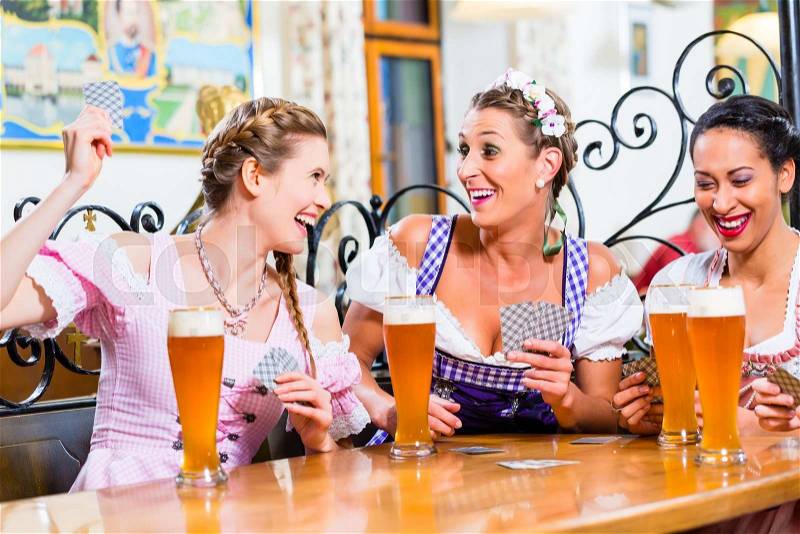 Women in Bavarian pub playing cards and a game of Schafkopf, stock photo