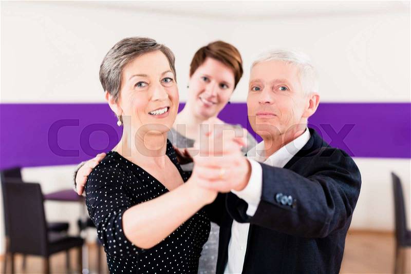 Dance instructor with senior couple of woman and man, stock photo