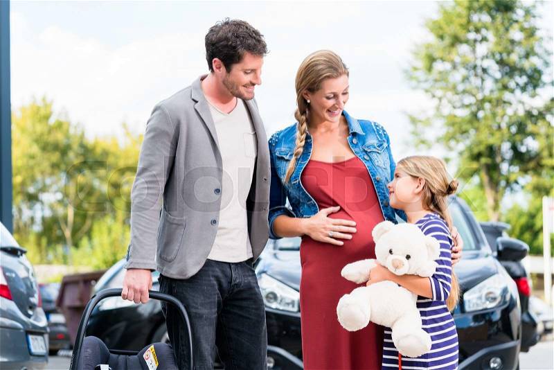Mother, father, and child buying car at dealership, a new family auto, stock photo