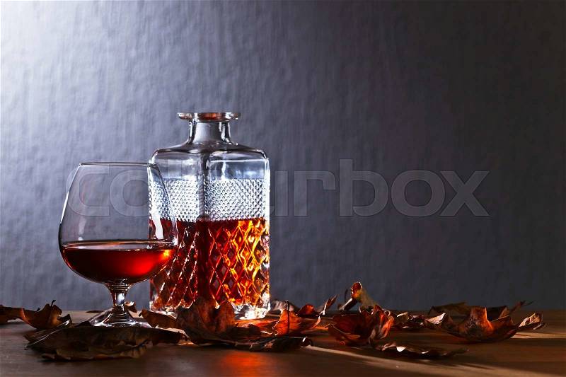 Snifter of brandy and dried oak leaves, stock photo