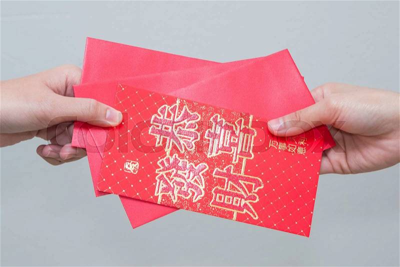 Woman hand giving red envelop containing money, with Good Luck character, during Chinese New Year celebration , stock photo