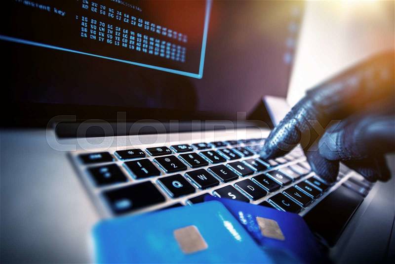 Credit Cards Theft Concept. Hacker with Credit Cards on His Laptop Using Them For Unauthorized Shopping. Unauthorized Payments, stock photo