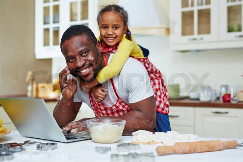 Busy father networking and speaking on cellphone with cute daughter on his back, stock photo