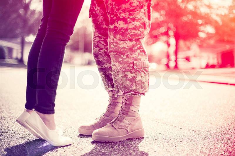 Young military couple kissing each other, homecoming concept, soft focus, cross process toning applied, light leak in the corner, stock photo