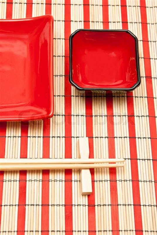 Red and black empty sushi set on the bamboo background, stock photo