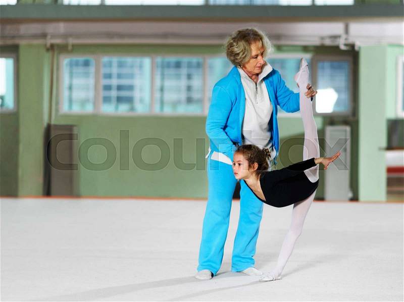 Coach teaches his daughter to do the balance in training, stock photo