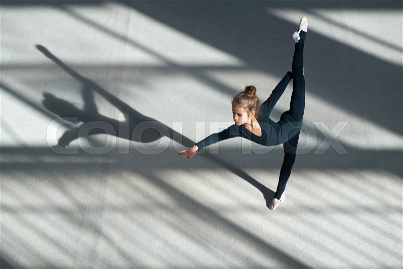 little girl doing balance on a rhythmic gymnastics , stock photo