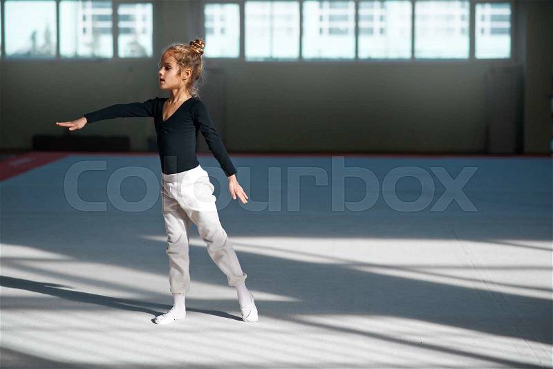 Girl practicing rhythmic gymnastics in the gym, stock photo