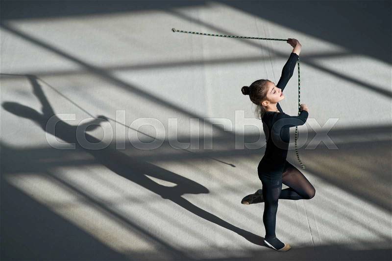Girl exercising with rope on the rhythmic gymnastics, stock photo