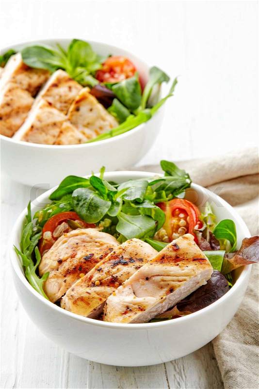 Two bowls of vegetable salad with grilled chicken fillet, stock photo