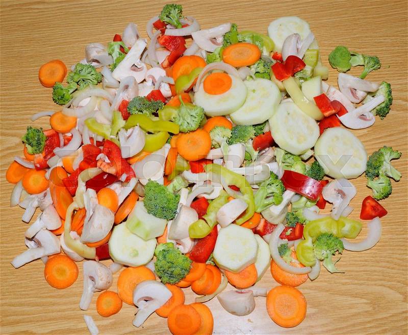 Miscellaneous fresh vegetables cut up in pieces ready for stir fry or saute. It includes carrots, broccoli, onions, asparagus, squash, and red and green pepper for healthy eating , stock photo