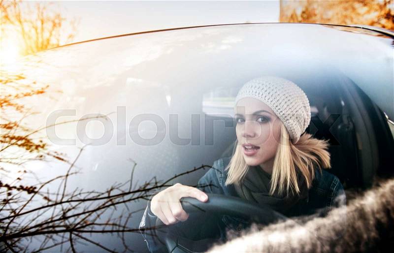 Beautiful young blond woman driving a car, stock photo