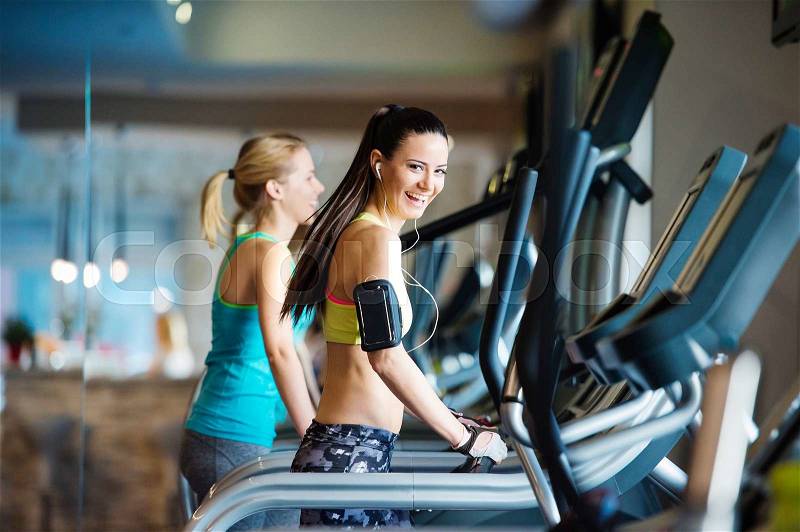 Two young beautiful women working out in gym, stock photo