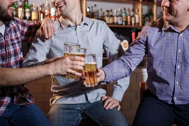 Happy smiling friends drinking beer at counter in pub, stock photo