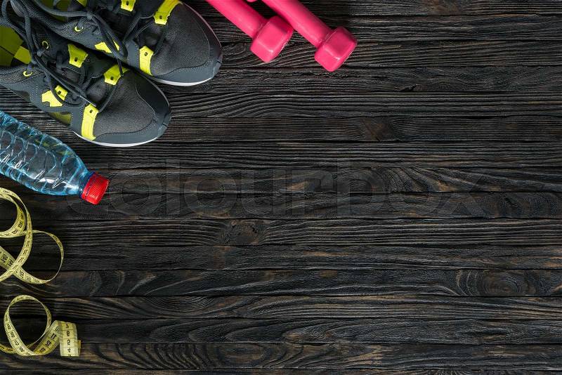 Sport fitness items on dark wooden background with empty text space, stock photo