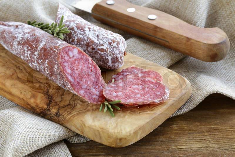 Delicacy smoked sausage (pepperoni) on a cutting board, stock photo