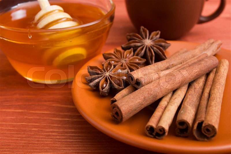 Cinnamon sticks and anise stars in a ceramic dish, stock photo