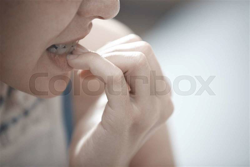 Close-up view on the woman biting nails, stock photo