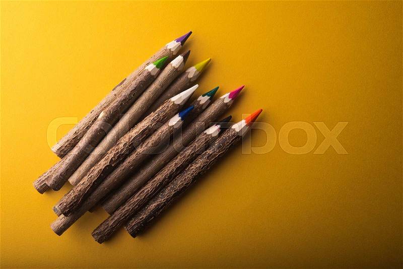 Wood color pencils on yellow background, stock photo