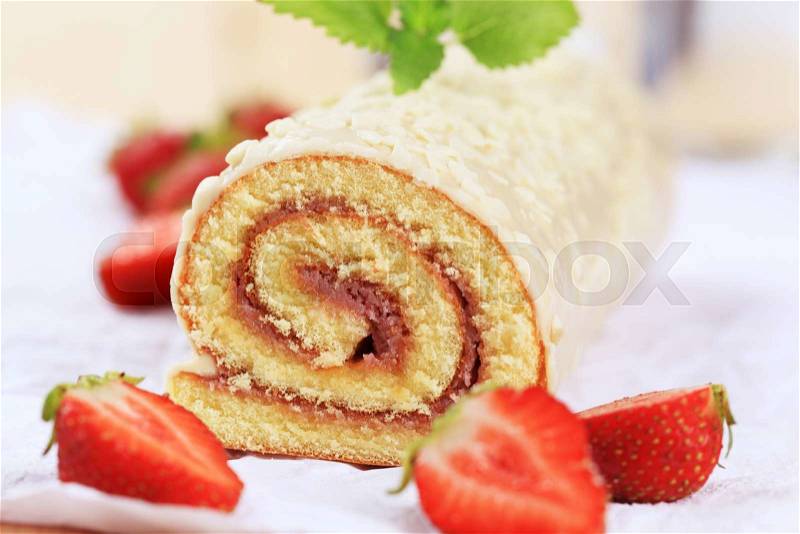 Swiss roll glazed with white chocolate icing, stock photo
