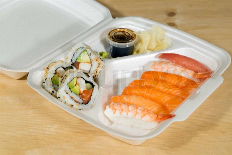Fast Food Sushi in its box on wooden table, stock photo