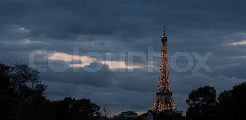 Eiffel Tower in Paris, France Sparkeling at Night with clouds behind it, stock photo