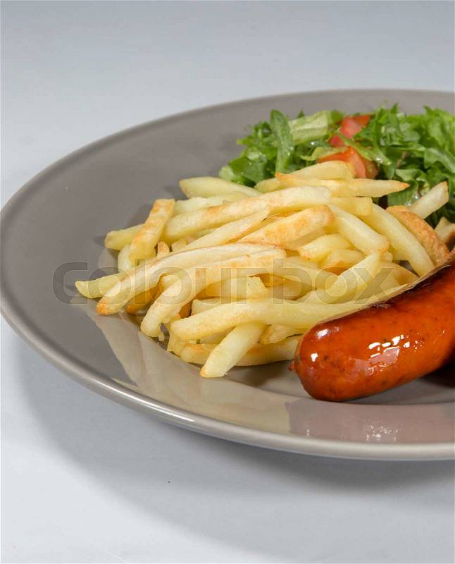 Sausage and French Fries on a plate with white background, stock photo