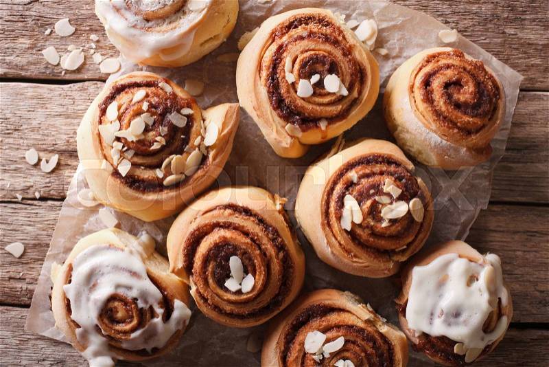Glazed Cinnamon rolls with almond close up on the table. horizontal top view , stock photo