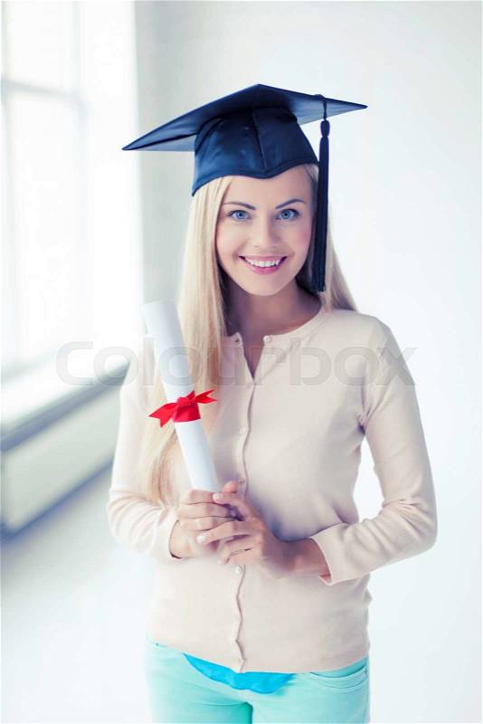 Happy student in graduation cap with certificate, stock photo