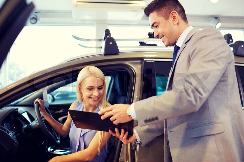 Auto business, car sale, consumerism and people concept - happy woman with car dealer in auto show or salon, stock photo