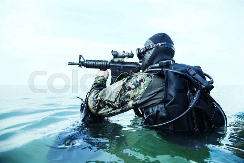 Navy SEAL frogman with complete diving gear and weapons in the water , stock photo