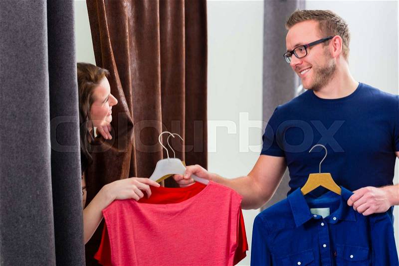 Couple trying clothes in shop changing room, stock photo