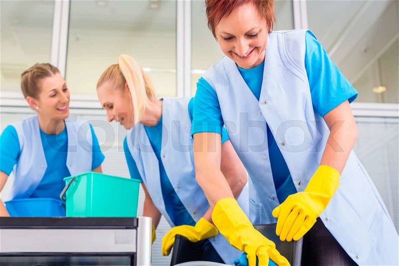 Commercial cleaning crew ladies working as team in office, stock photo