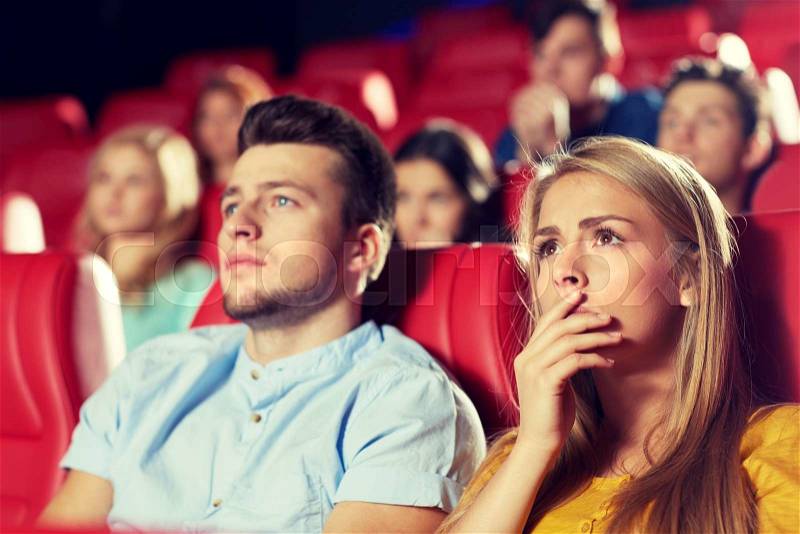 Cinema, entertainment and people concept - happy friends watching horror, drama or thriller movie in theater, stock photo