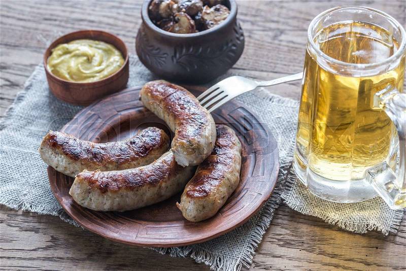 Grilled sausages with fried bacon rashers and mushrooms, stock photo
