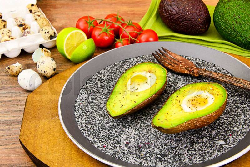 Avocados, baked with quail egg, salt, pepper and lemon Studio Photo, stock photo