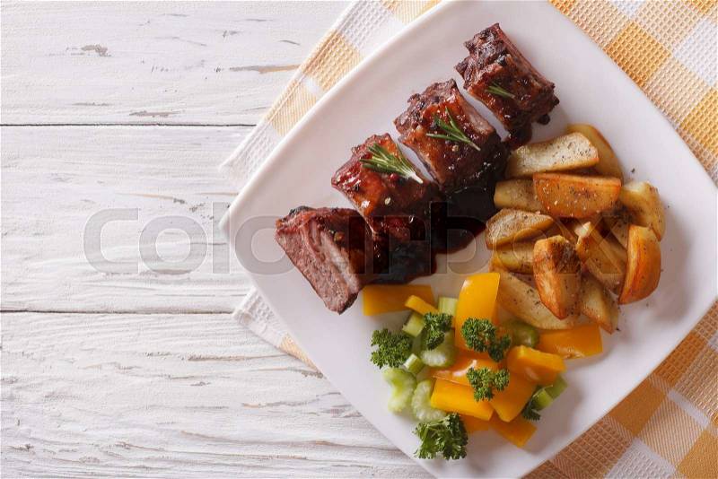 BBQ pork ribs with a side dish of vegetables on a plate. horizontal view from above , stock photo