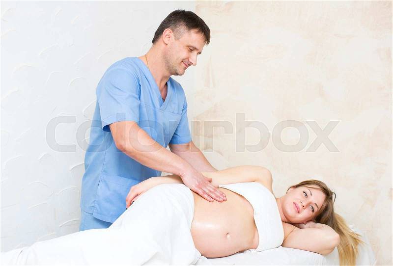 Processes salon doing massage to a pregnant woman, stock photo