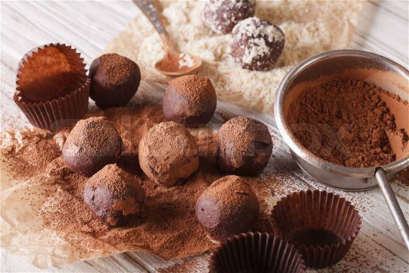 Chocolate truffles sprinkled with cocoa powder and nuts close-up on the table. horizontal , stock photo