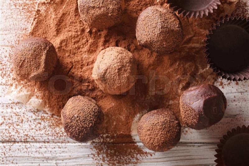 Chocolate truffles in cocoa closeup on a wooden table. horizontal view from above , stock photo